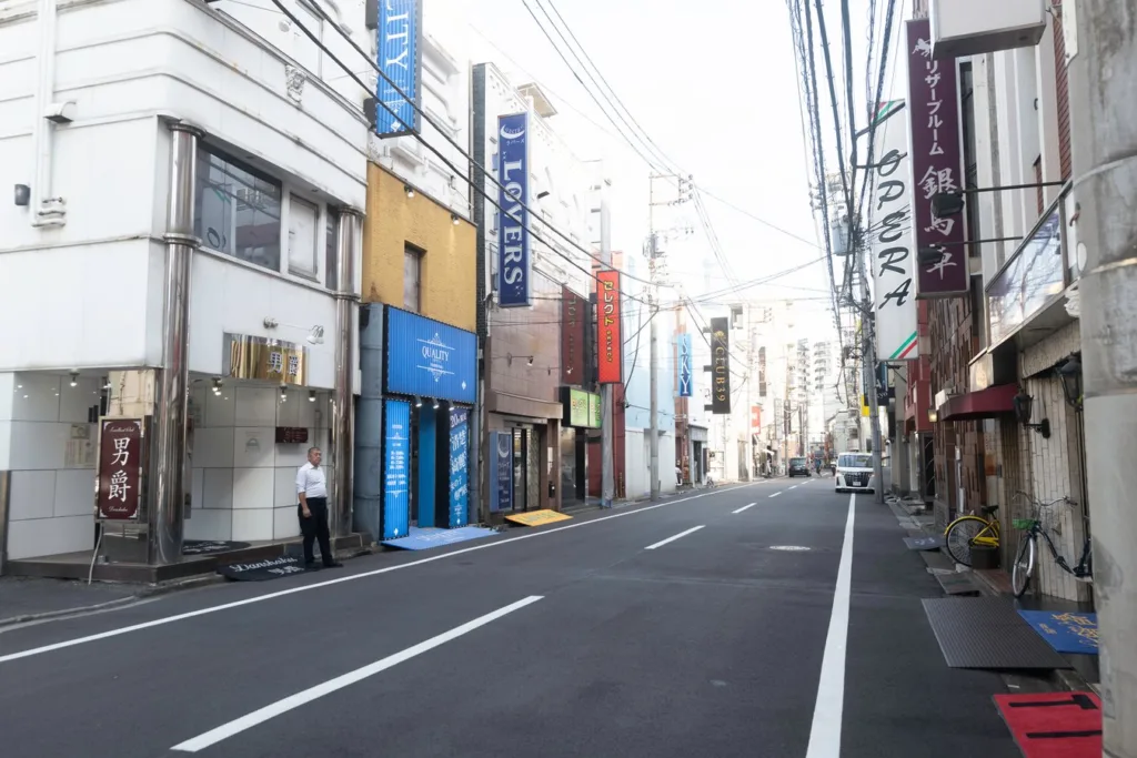 Quiet street scene in a Japanese city, showcasing local architecture and signage. Ideal for immersive Japan tours.