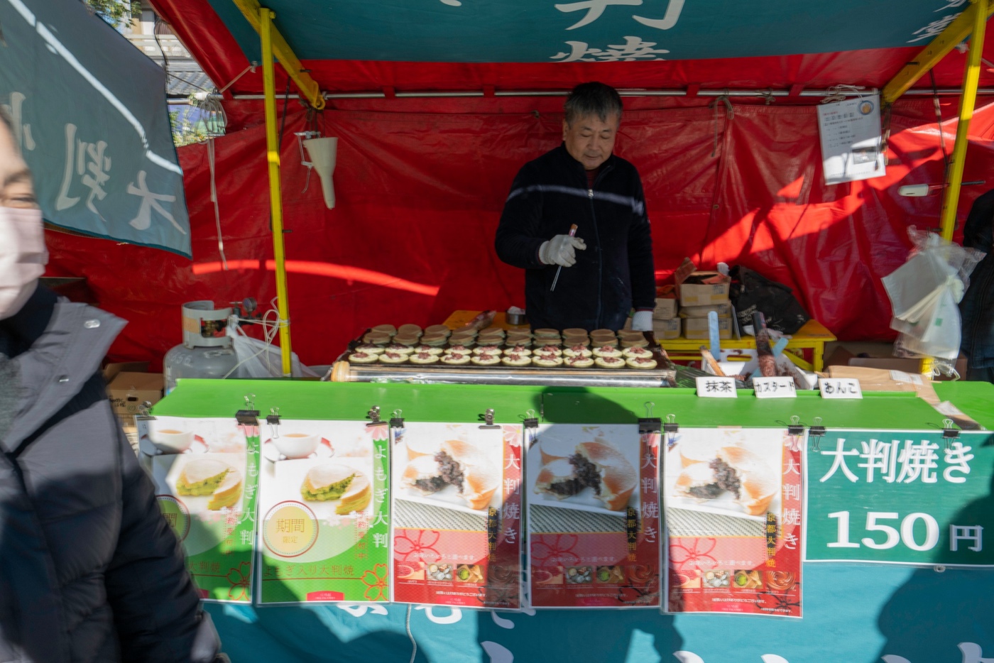 Puesto de comida callejera de dorayaki en Kioto que vende ōbanyaki recién hecho por ¥150, con relleno de matcha, natillas y anko
